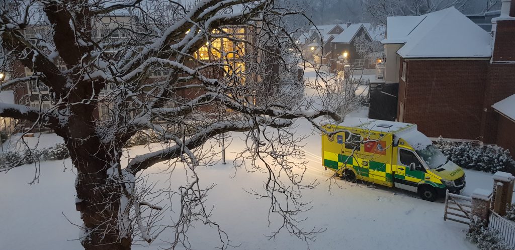 Ambulance parked in snowy residential street