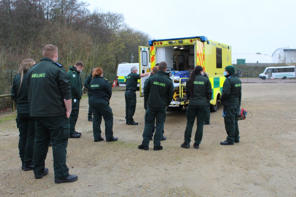 Group of people standing in front of an ambulance