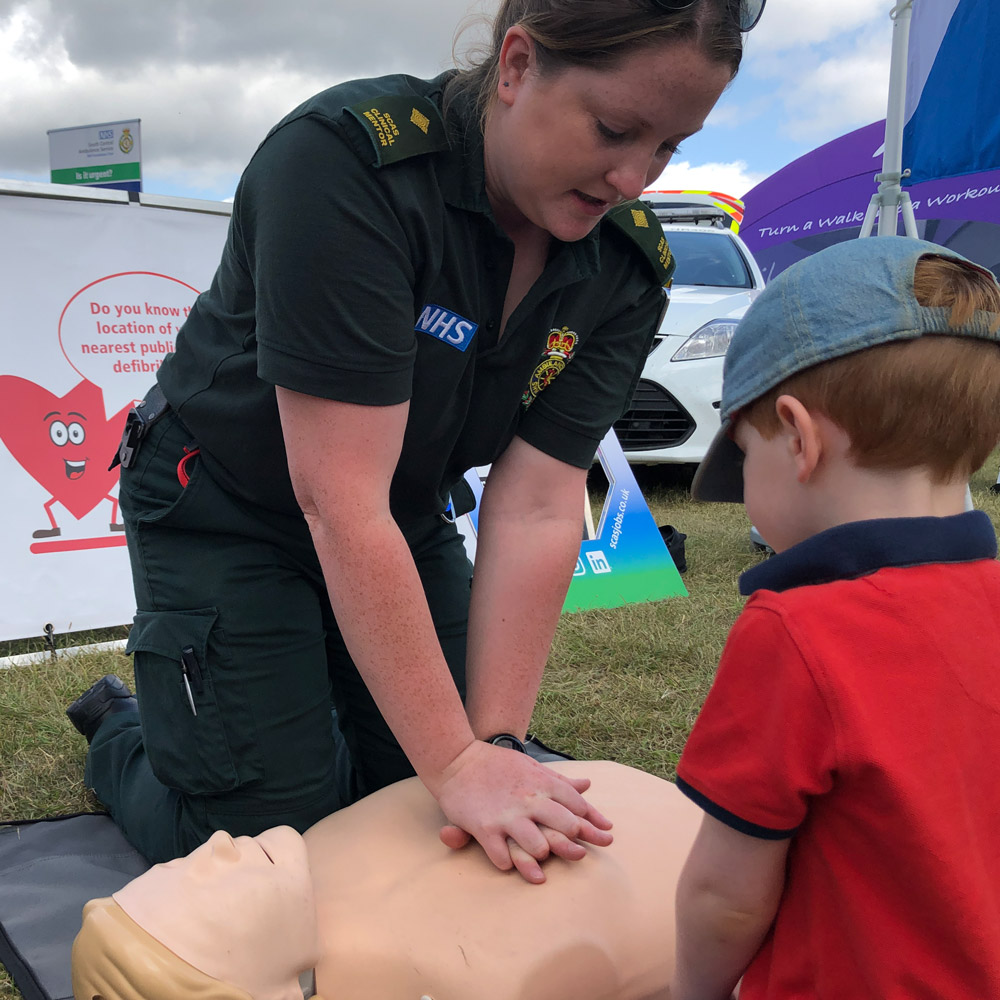 SCAS paramedic demonstrating CPR to a child