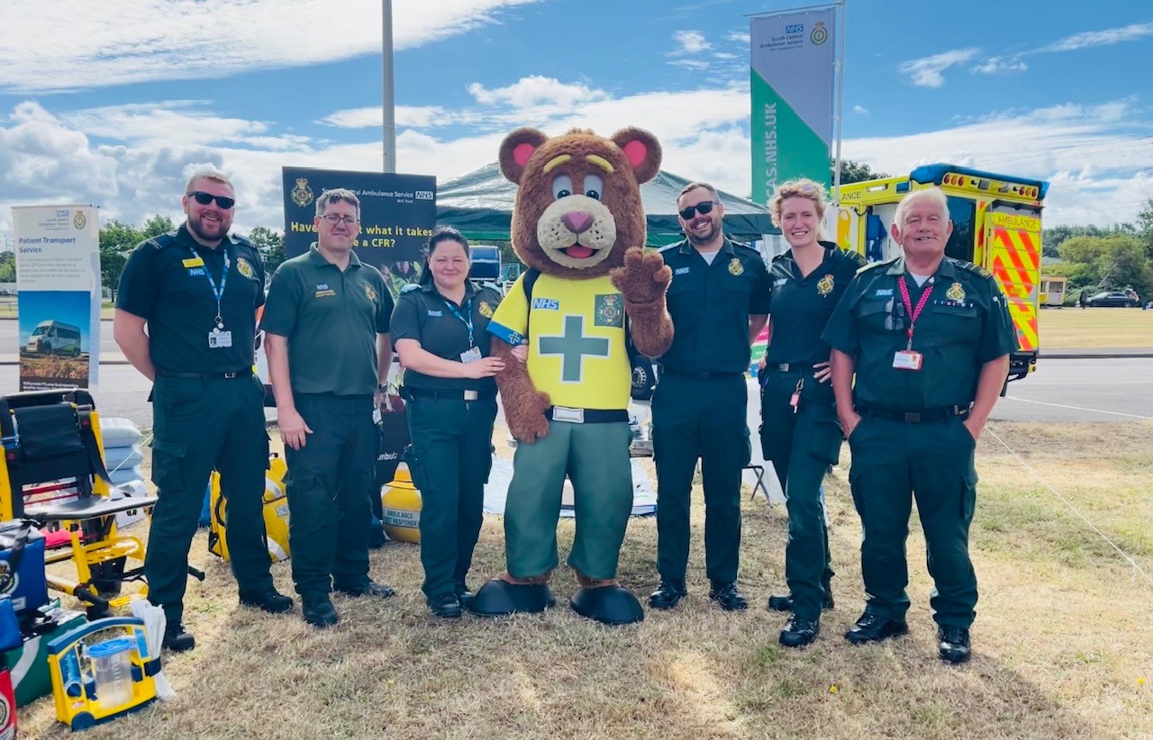 SCAS colleagues standing along SCAS mascot 999 Ted