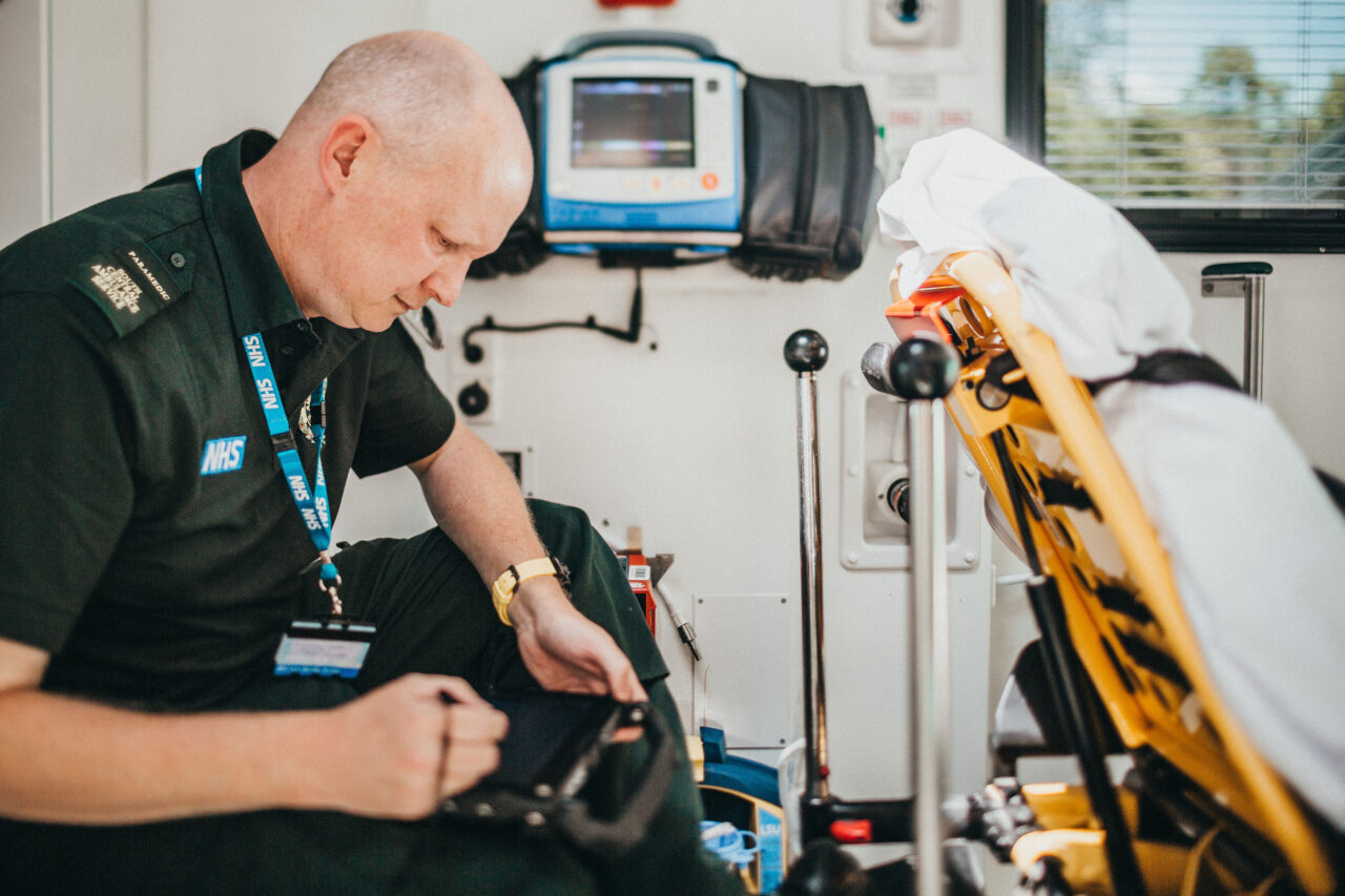 Paramedic sitting in back of ambulance