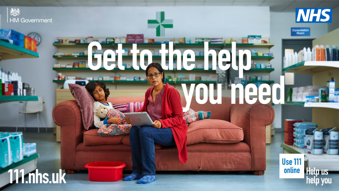 A mother and child are sitting on a sofa inside a pharmacy.