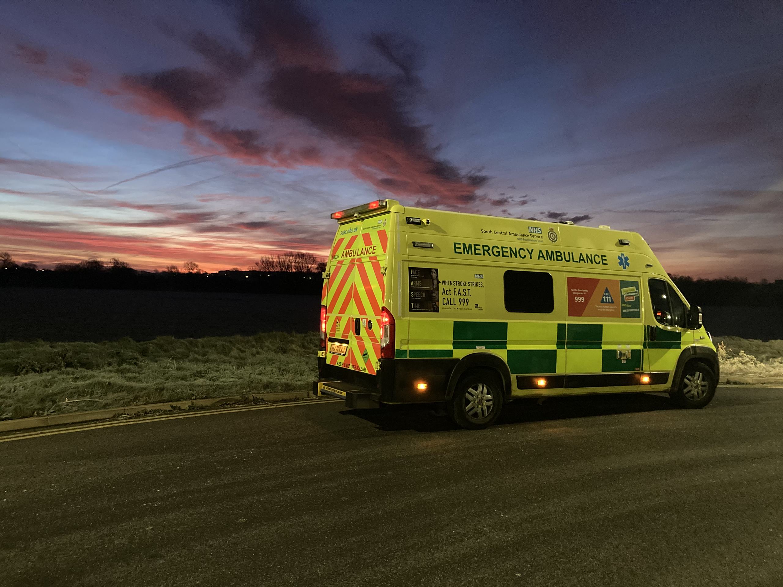 Ambulance parked at dusk on rural road