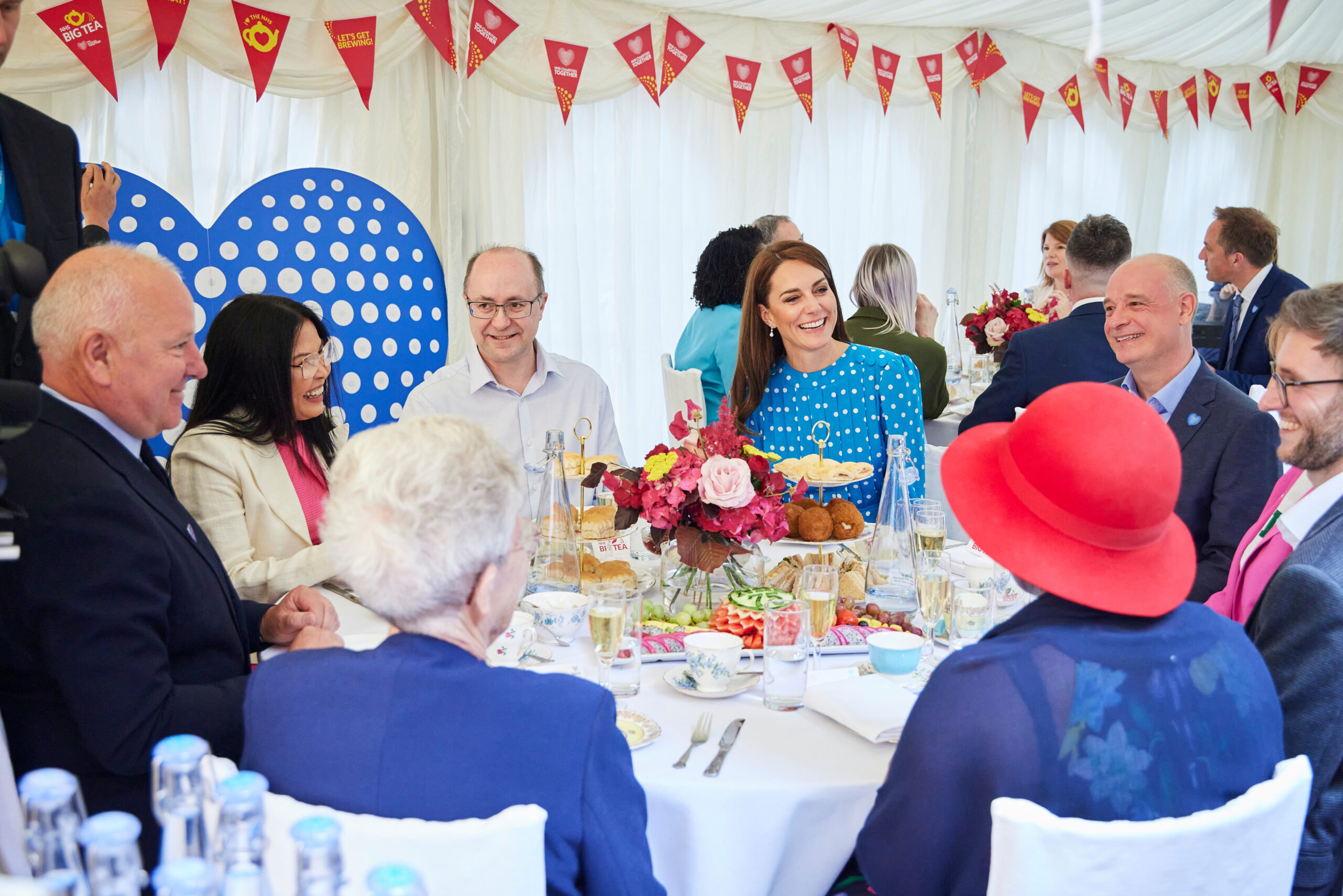 A group of people having afternoon tea around a table with the Princess of Wales