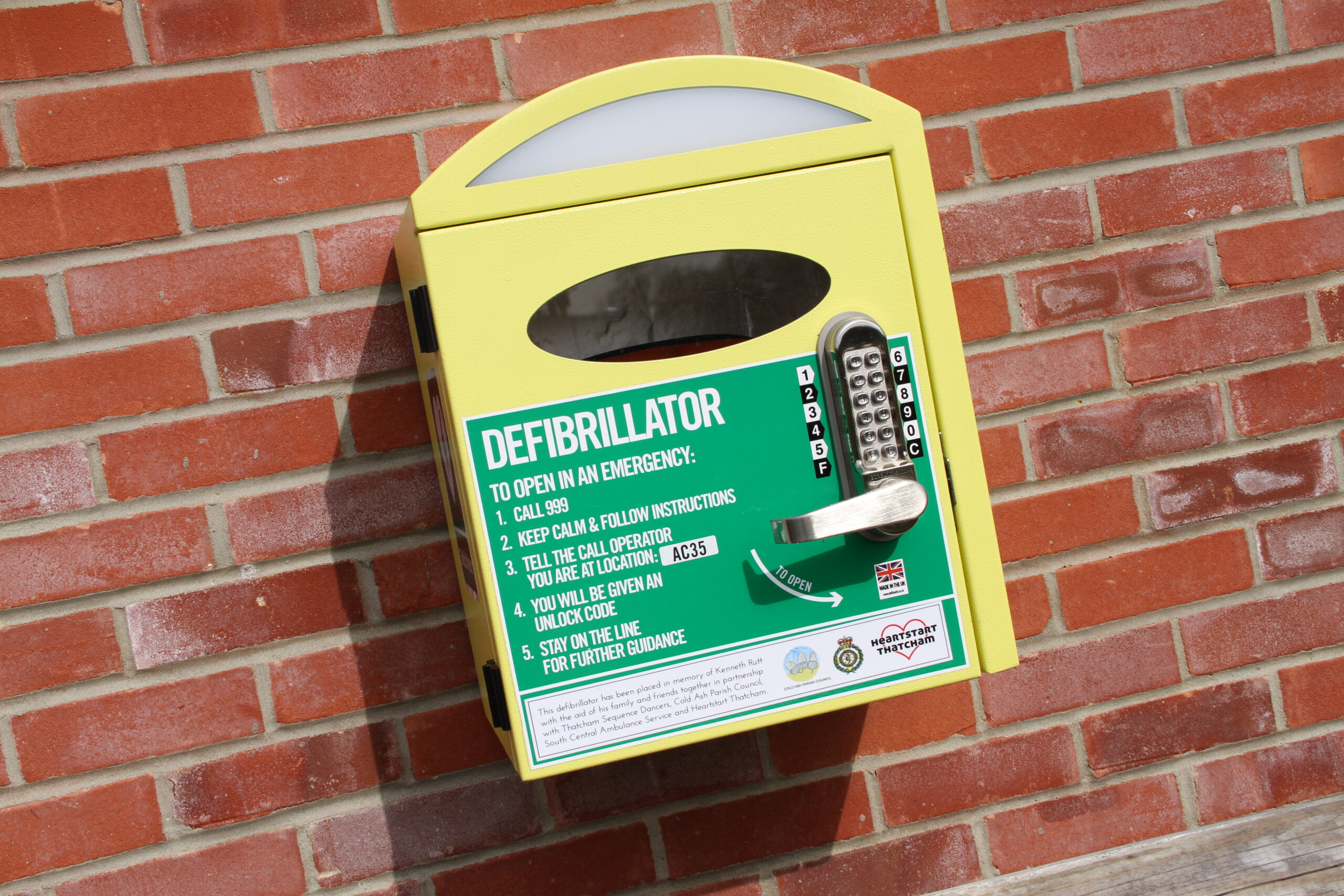 Cabinet containing publicly accessible defibrillator fixed to an outside wall