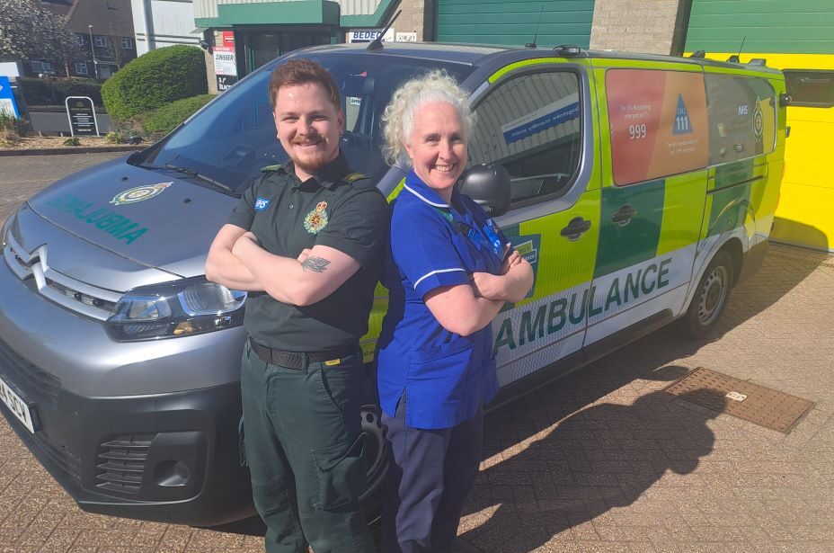 Two members of the falls and frailty team standing by an ambulance