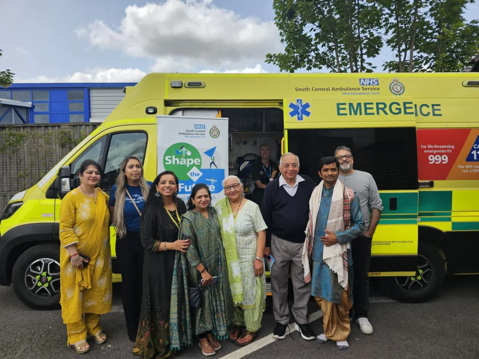 Members of the public and our research team standing in front of an ambulance.
