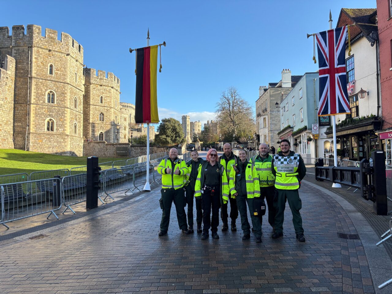 A group of ambulance service staff in uniform standing outside Windsor Castle