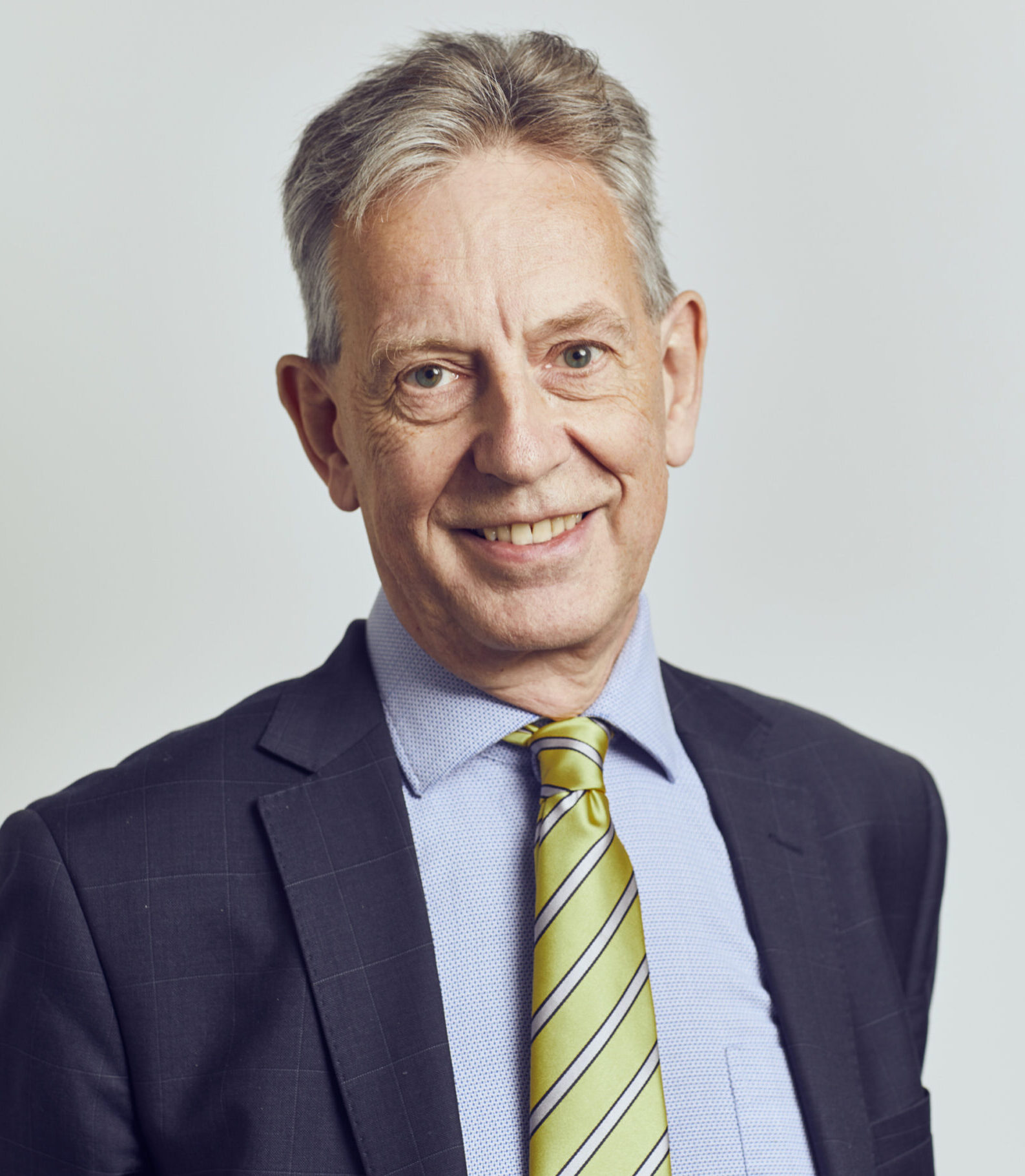 A head and shoulders image of a man wearing a suit