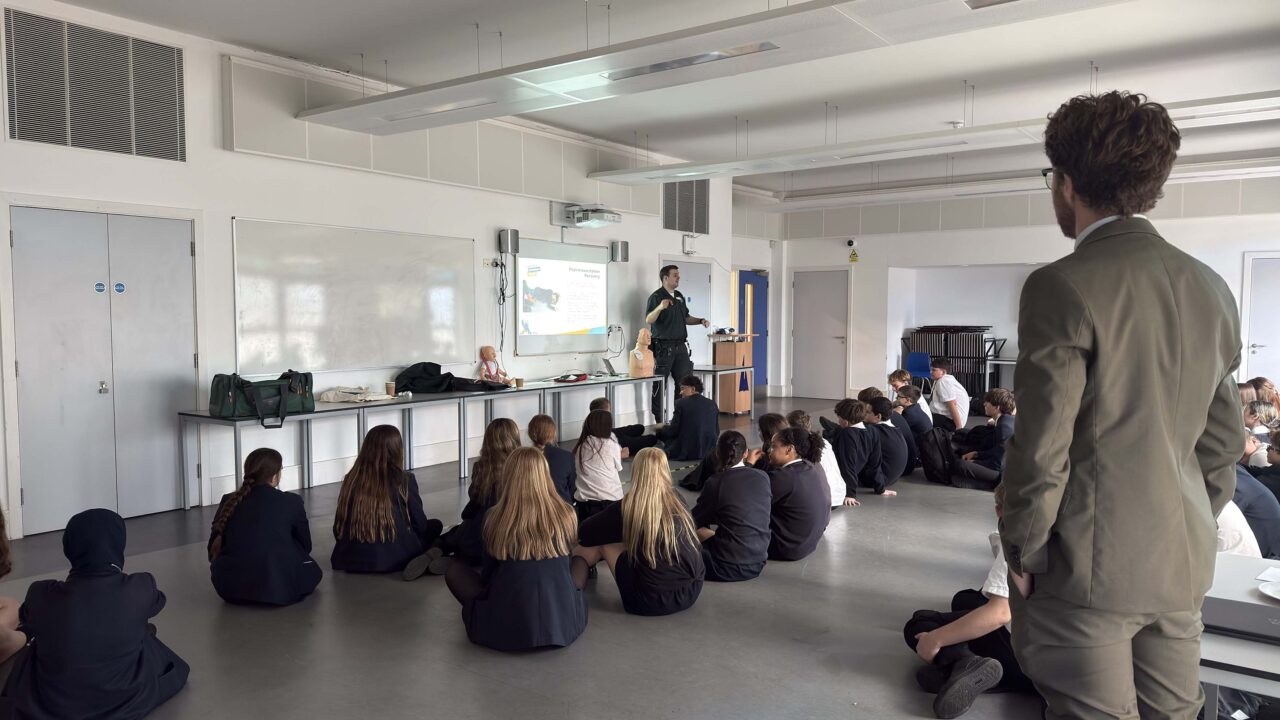 Paramedic delivering training to room of school pupils